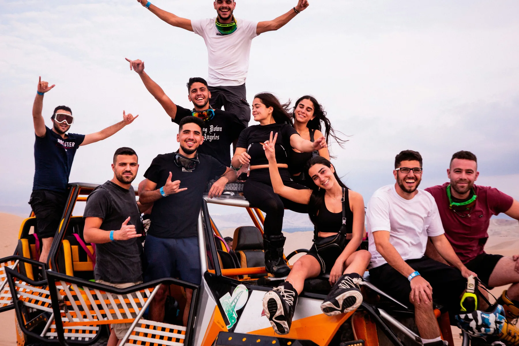 Buggy Tour Gran Canaria - Gruppen & Events - Gruppe von Freunden feiert auf einem orangefarbenen Buggy bei Sonnenuntergang